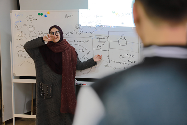 ConnectHER Fellow Aya Matrabie teaching a filmmaking class in front of her young students.