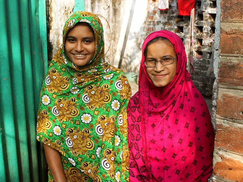 Image shows Asma and her little sister smiling at the camera.